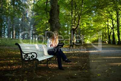 young woman with laptop in the park