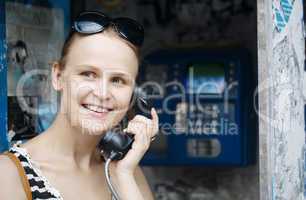 attractive woman using a public telephone