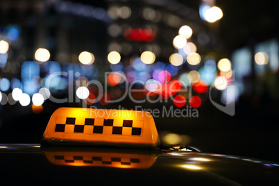 illuminated taxi cab sign on a city street