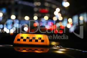 illuminated taxi cab sign on a city street