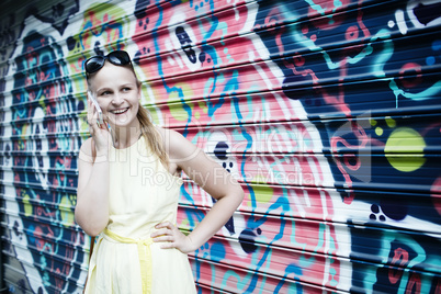 woman chatting on her mobile in front of graffiti