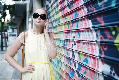 woman chatting on her mobile in front of graffiti