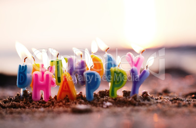 birthday candles burning on a seashore