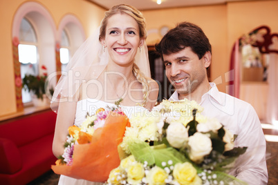 smiling bride and groom with bouquets of flowers