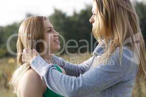 two sisters or female friends in a close embrace