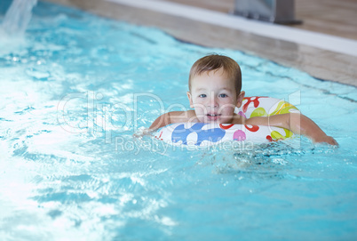 kid learns to swim using a plastic water ring