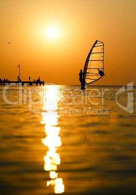 silhouette of surfer at sunset passing by