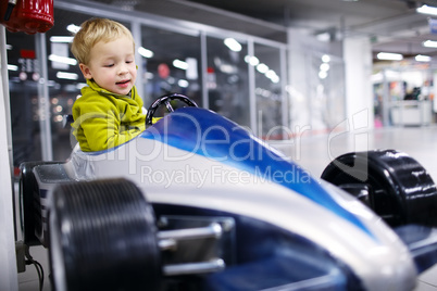 little boy driving a racing car