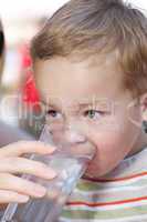 little boy drinkng a glass of fresh water