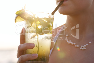woman enjoying a tropical mojito cocktail