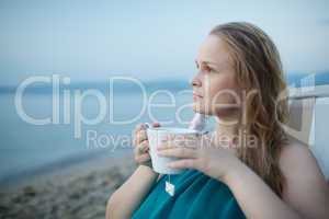 woman enjoying a cup of tea at the seaside