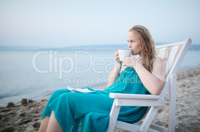 woman enjoying a cup of tea at the seaside