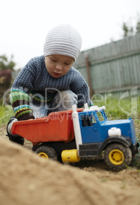 boy playing with toy truck outdoor