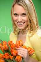 smiling woman hold spring  flowers orange tulip