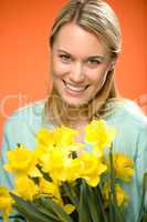 smiling woman hold yellow narcissus spring flowers