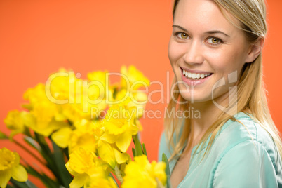 smiling woman with spring yellow narcissus flowers