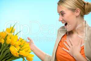 surprised woman receive bouquet of yellow tulips