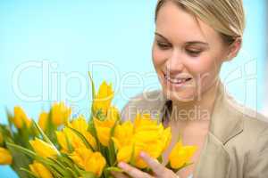 woman looking down at spring yellow tulips