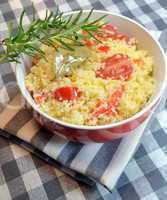 Couscous with vegetables cooked in a red bowl
