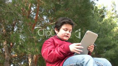 Little boy by himself and using a digital tablet