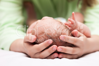 Cute sleeping newborn baby child on mother hands