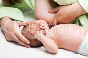 Little newborn baby child sucking or eating mother breast milk