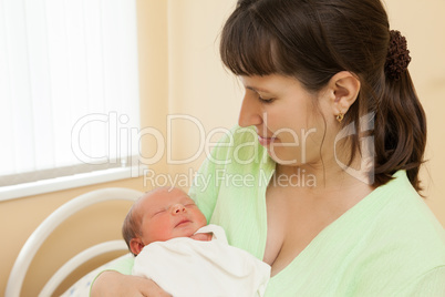 Cute sleeping newborn baby child on mother hands