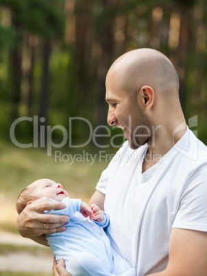 Father and newborn baby son walking outdoor