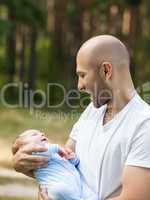 Father and newborn baby son walking outdoor