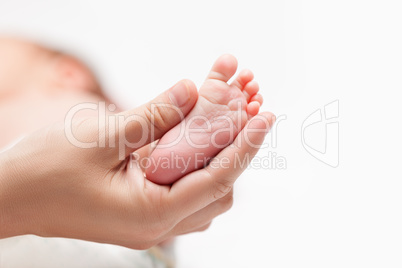 Newborn baby child little foot with heel and toes in mother hand