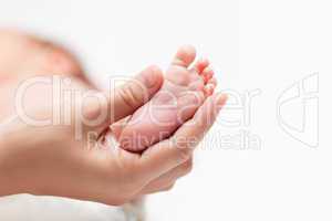 Newborn baby child little foot with heel and toes in mother hand