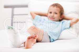 Little child boy with plaster bandage on leg heel fracture or br