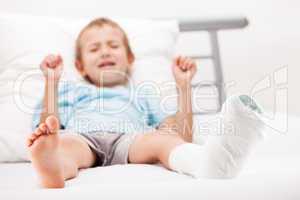 Little child boy with plaster bandage on leg heel fracture or br