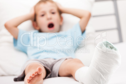 Little child boy with plaster bandage on leg heel fracture or br