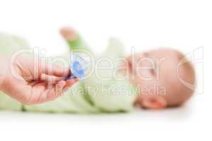 Mother giving soother pacifier to little sleeping newborn baby c