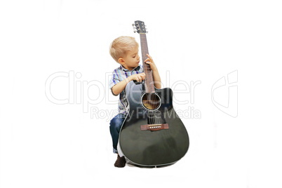 Little boy learning to play guitar