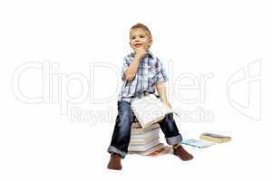 Little boy sitting on stack of books. Isolated over white