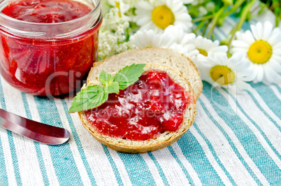 Bread with strawberry jam and knife on a napkin