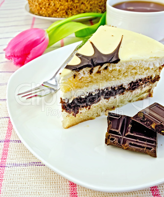 Cake with chocolate and pink tulips on the tablecloth