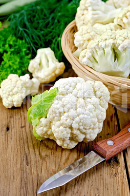 Cauliflower with a basket and knife on board