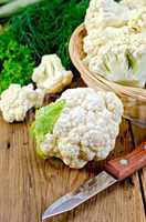 Cauliflower with a basket and knife on board