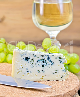 Cheese blue on board with wine and grapes
