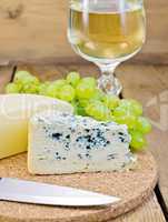 Cheese different with grapes and wine on the board