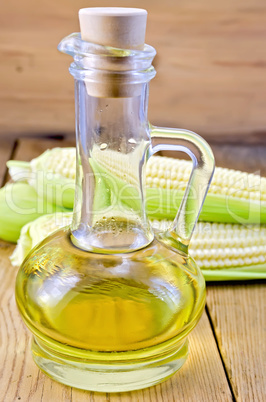 Corn oil in a carafe with corncobs on board