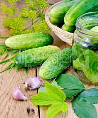 Cucumbers in jar and a wicker basket with leaves