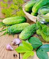 Cucumbers in jar and a wicker basket with leaves