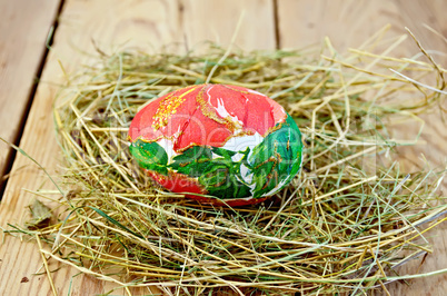 Easter egg with a red flower in the hay