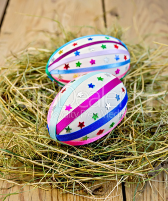 Easter eggs with ribbons and sequins in the hay