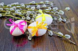 Easter eggs with ribbons and willow on the board