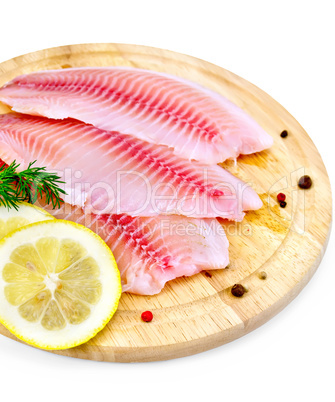Fillets tilapia with lemon and dill on a board